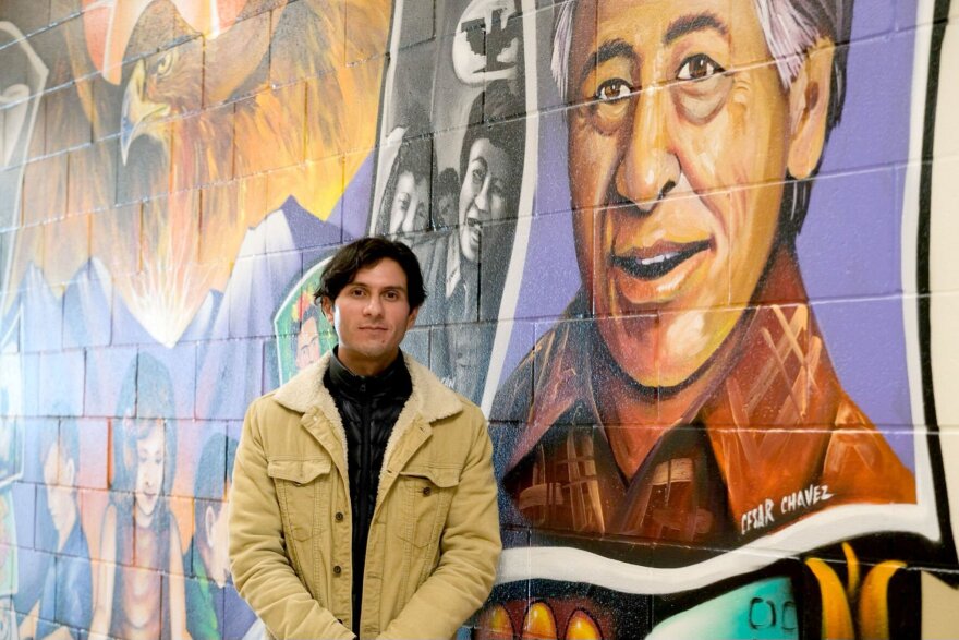 Eduardo Chavez stands next to a mural of his grandfather, labor leader Cesar Chavez.