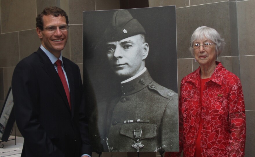 State Treasurer Clint Zweifel and Margaret Means, a relative of Maj. Slusher, stand with a portrait of Maj. Slusher taken in uniform with the Distinguished Service Cross.