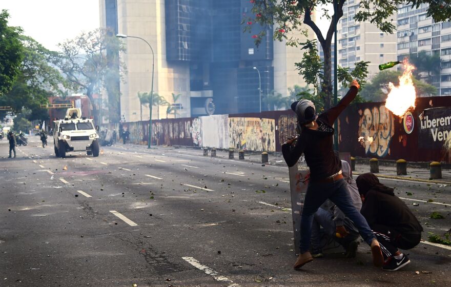 Demonstrators hurl flaming objects at riot police during the anti-Maduro rally in Caracas.