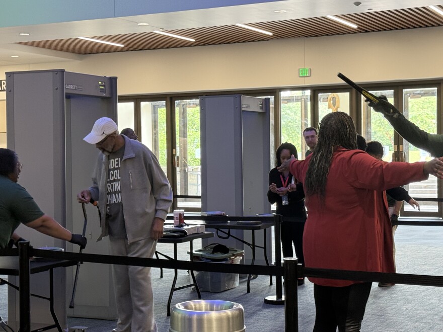 Tyrone Burkhead, center left, passes through security inside the UAF Fine Arts Complex before entering the Davis Concert Hall July 14, 2026.