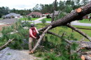 Jeff Lundy cuts up a pine tree that fell on his father-in-law's house during Isaias on Saturday, Oct. 10, 2026, in Milton, Fla.