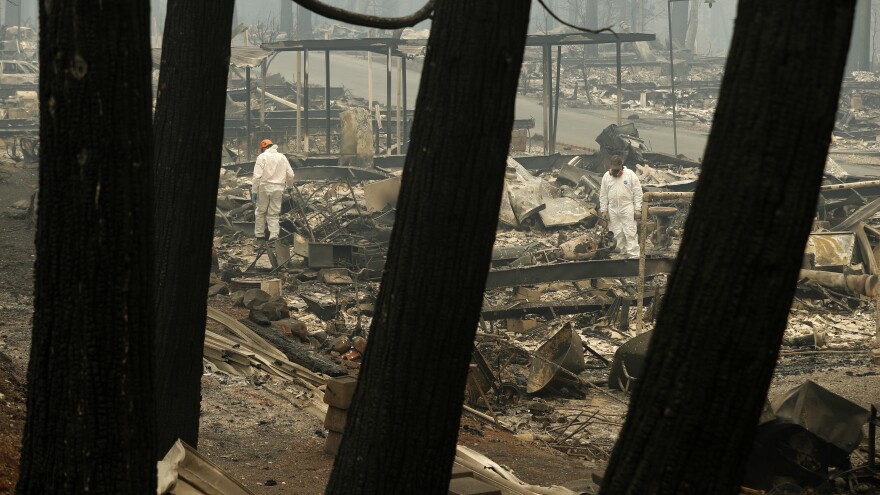 Workers search for human remains at a trailer park burned out by the Camp fire, Tuesday, in Paradise, Calif.