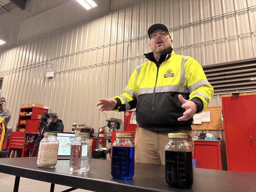 Eric Bowman demonstrates treatments used on Kentucky roadways. From left to right, rock salt, salt brine, calcium chloride, and a combination of salt brine and desugared beet juice. Salt brine is effective at temperatures above 25 degrees. Once temperatures drop lower than that, calcium chloride is used to lower the freezing point of water and increase the effectiveness of salt. This year, the department is transitioning away from the use of calcium chloride and toward the use of an agricultural byproduct derived from beet juice, which functions similarly but causes less corrosion to trucks and is less hazardous to the surrounding environment.