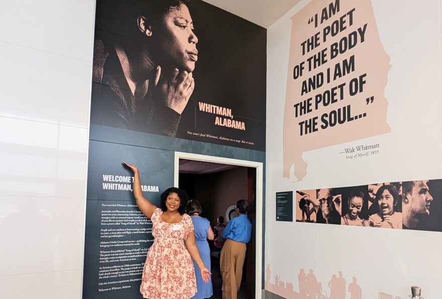 Curtia Torbert, a film participant whose image illustrates signs for the airport exhibit, poses in front of the theater during the opening reception
