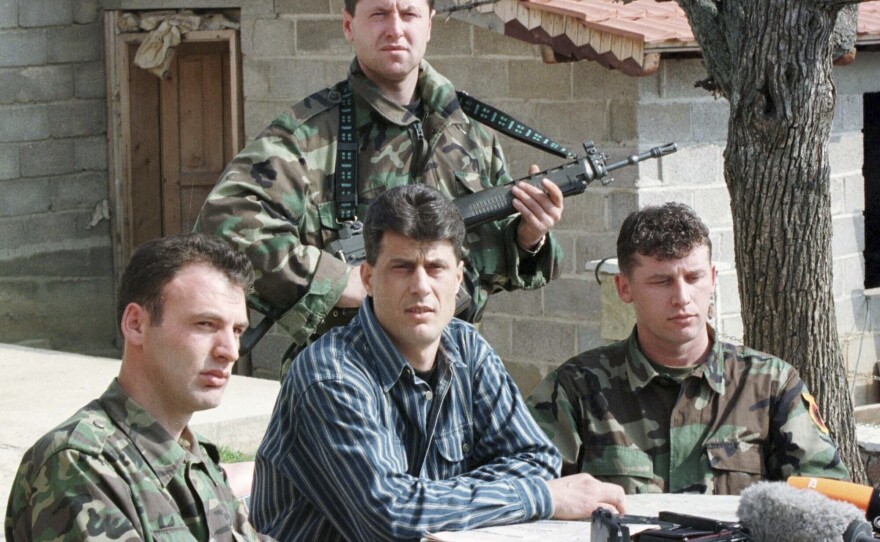 Thaci, center, then a senior commander in the Kosovo Liberation Army guerrilla group, addresses a news conference in 1999 in a secret location in central Kosovo.