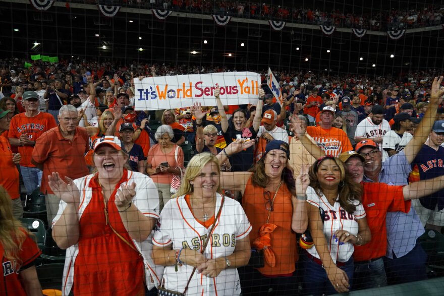 Astros and Red Sox fans cheer from the stands.