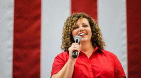  Celeste Maloy speaking in front of an American flag.