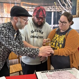 Professor Kurt Gohde, Billy Dawson, and Keisha Fielden hold the jar of meat.