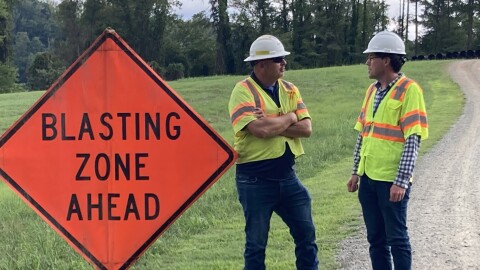 Inspector Travis Goode and spokesman Westley Kern stand by as the Rivanna Water and Sewer Authority prepares to blast through rock that's blocking a pipeline's path.