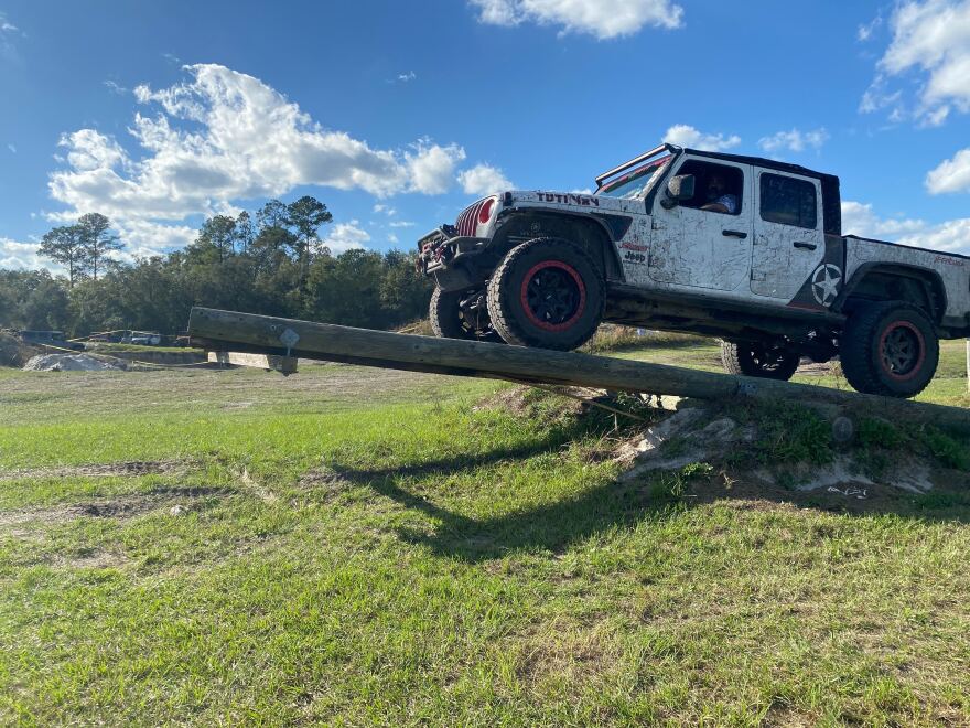 A driver testing their jeep’s suspension limits while trying to balance on the teeter-totter. (Jonathan Acosta/WUFT News)