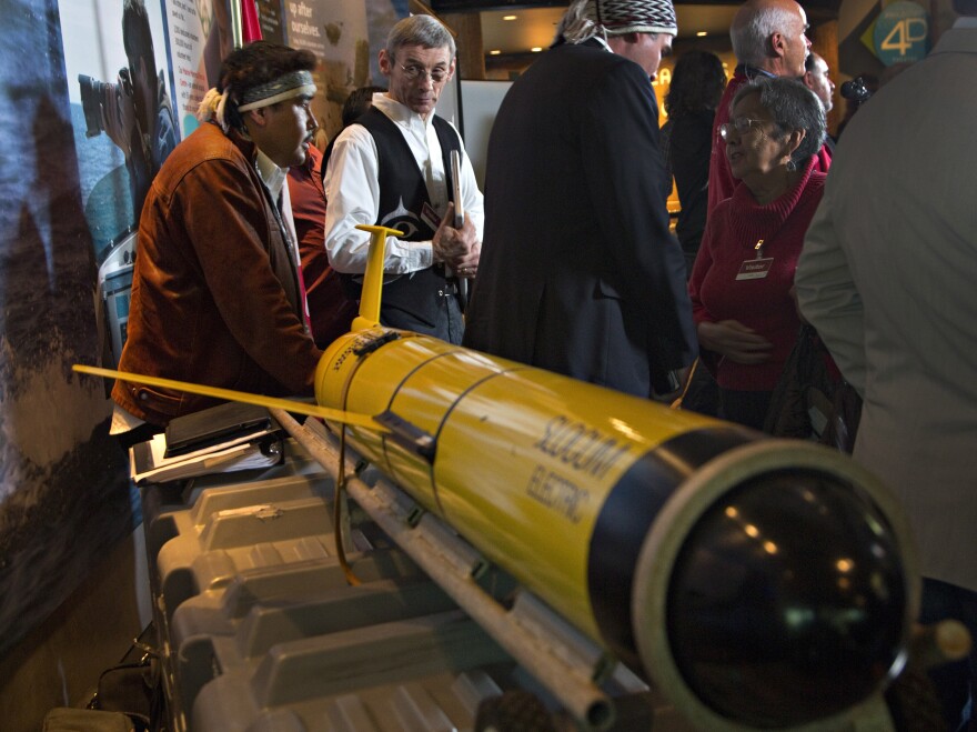 John Disney (second from left) looks over the underwater probe used in his company's ocean fertilization project, at a news conference in Vancouver, British Columbia, in October.