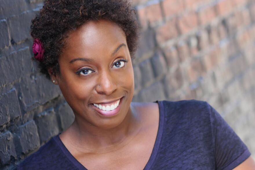 Young African America woman smiles for the camera.