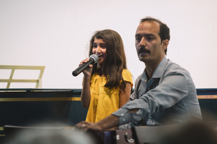 Bloomington Early Music Festival on Wednesday, May 22, 2024 at FAR Center For Contemporary Arts. A young girl sings into a microphone with a man next to her.