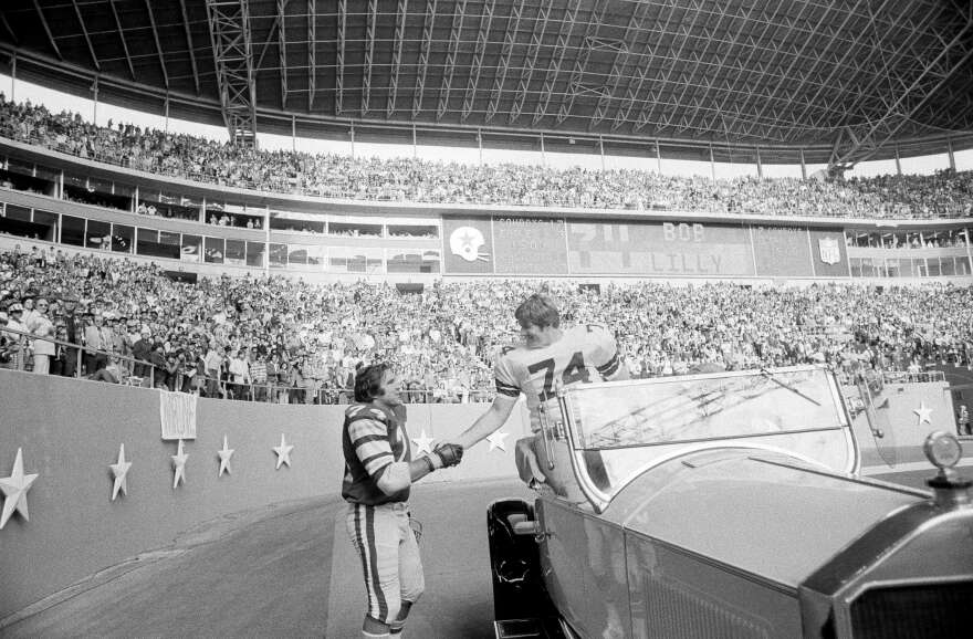 Philadelphia Eagles guard John Niland (74), right, shakes hands with retired Dallas Cowboys tackle Bob Lilly (74) during half-time ceremonies honoring Lilly at Texas Stadium in Irving, Nov. 23, 1975. Niland and Lilly were teammates the previous year.