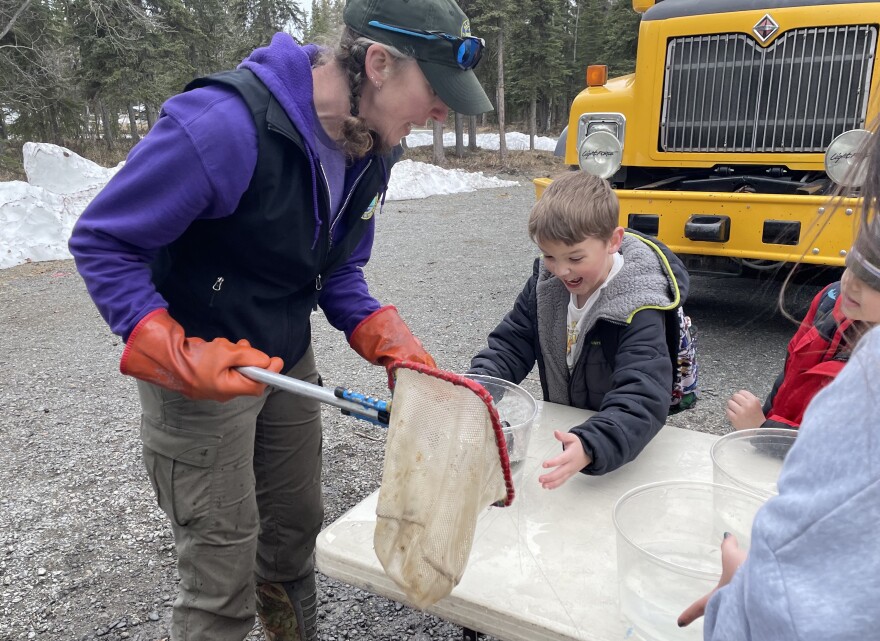 Summer Woods helps a student with their trout.