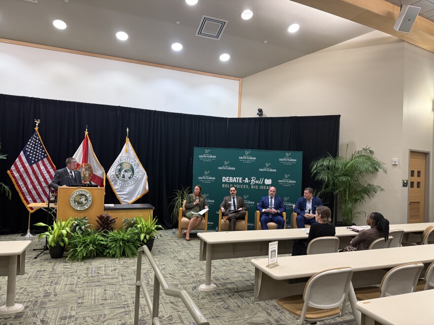 Four panelists sit in an auditorium at USF to debate the prospect of eliminating property taxes in Florida 