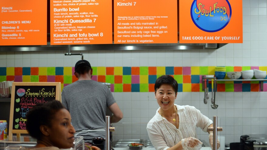 Anna Goree (right) talks to customer Tioni Collins while Anna's husband, Jon Goree, prepares the food at Seoul Food D.C. restaurant, which is located inside an Exxon gas station. "My wife Anna is not only an excellent cook; she knows everyone by name and has good rapport with our customers," Jon tells The Salt.