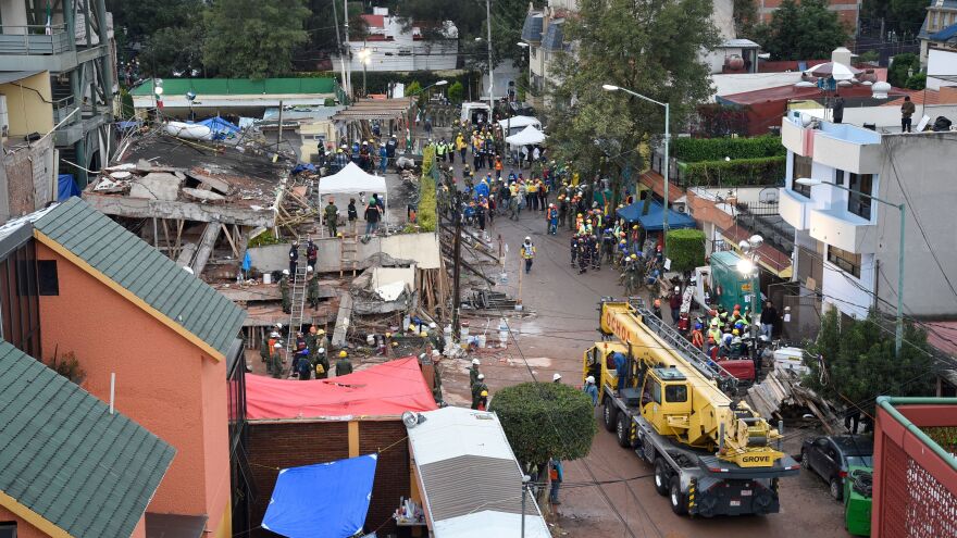Rescuers, firefighters, policemen, soldiers and volunteers look for survivors in a flattened building in Mexico City on Thursday, as part of a widespread search for people who lived through a strong earthquake.