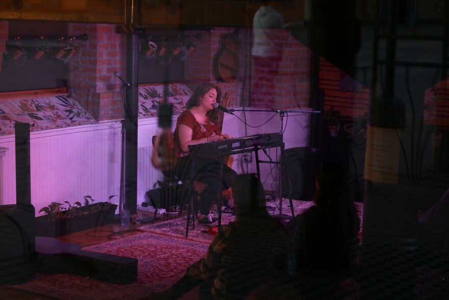 Woman on stage playing a keyboard and singing