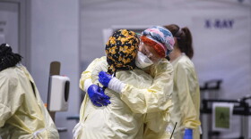 Medical worker Margaret Watkins embraces co-worker Shelly Burke as part of their morning therapy, a family check in. (JOSEPH PREZIOSO/AFP via Getty Images)