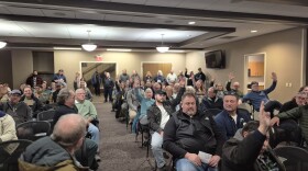 Mason residents raise their hands after Mayor Russell Whipple told city planners that many of the people opposed to the zoning proposal lived outside of the city.