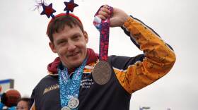 Jason Criss holds aloft his silver medal from the 2026 Special Olympics USA Games during the Independence Day parade in Kenai, Alaska, on July 4, 2026.