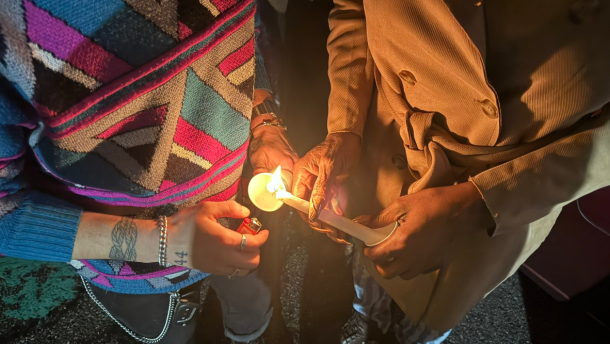 Attendees at Diversity Richmond's 2024 Transgender Day of Remembrance and Resilience light candles as part of the annual event. 