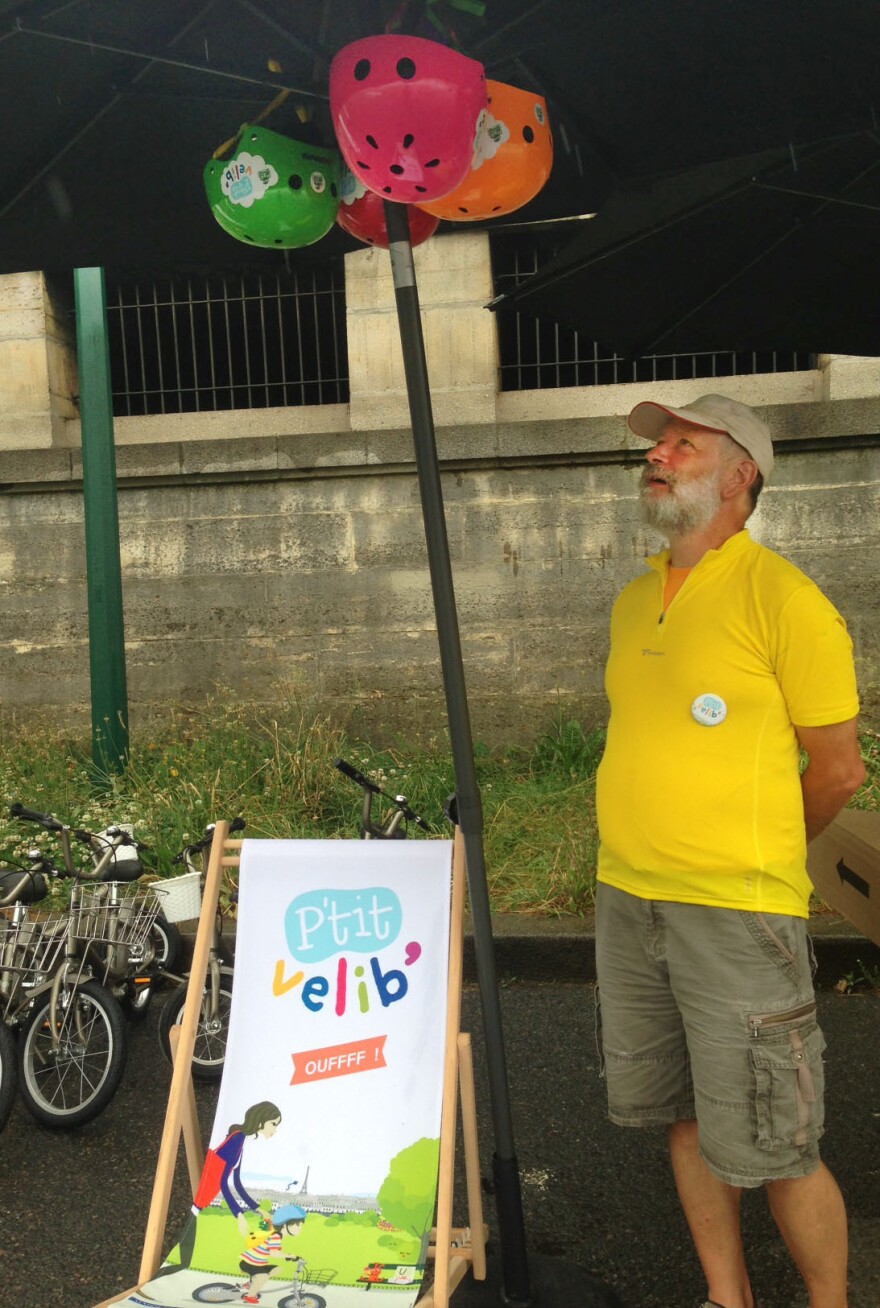 Joel Sick displays colorful helmets for rent at his P'tit Velib stand. His bikes come in four different sizes for children ages 2-8.