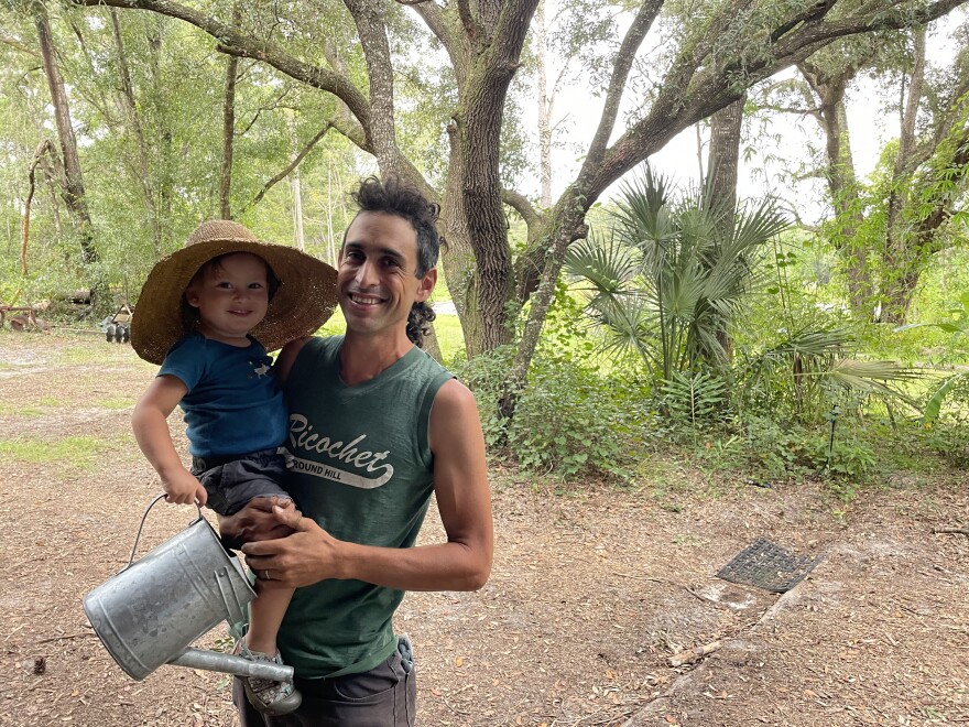 After a full day of hurricane preparation on Sept. 27, 2022, farmer Daniel Robleto of Gainesville, Florida, is seen here with his son. Robleto said many farmers across Florida recognize the state's climate is a gamble. (Katie Delk/Fresh Take Florida)