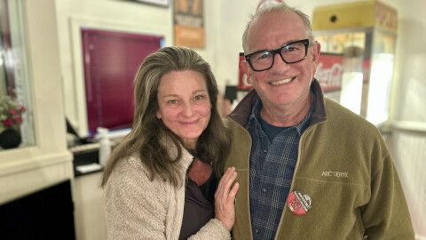 Carbondale residents Helen Copping and Martin Evans pose in front of the concession stand inside the Crystal Theatre after an information session about the statewide ballot measures on Oct. 21, 2026.