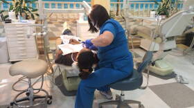 A hygienist numbs a patient in preparation for a tooth extraction at Smiles of Hope.