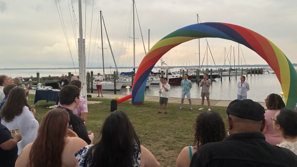 People standing near a dock with a pride display