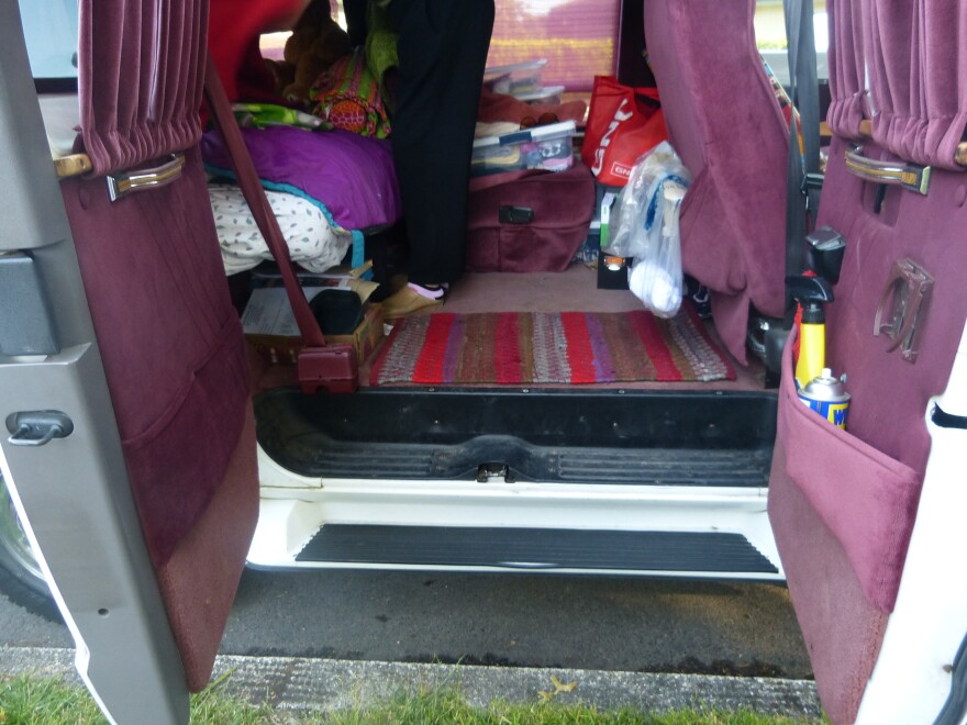 The back of Elizabeth Jay's Dodge Ram minivan is cluttered with her clothes and supplies because the van is her living room and bedroom.