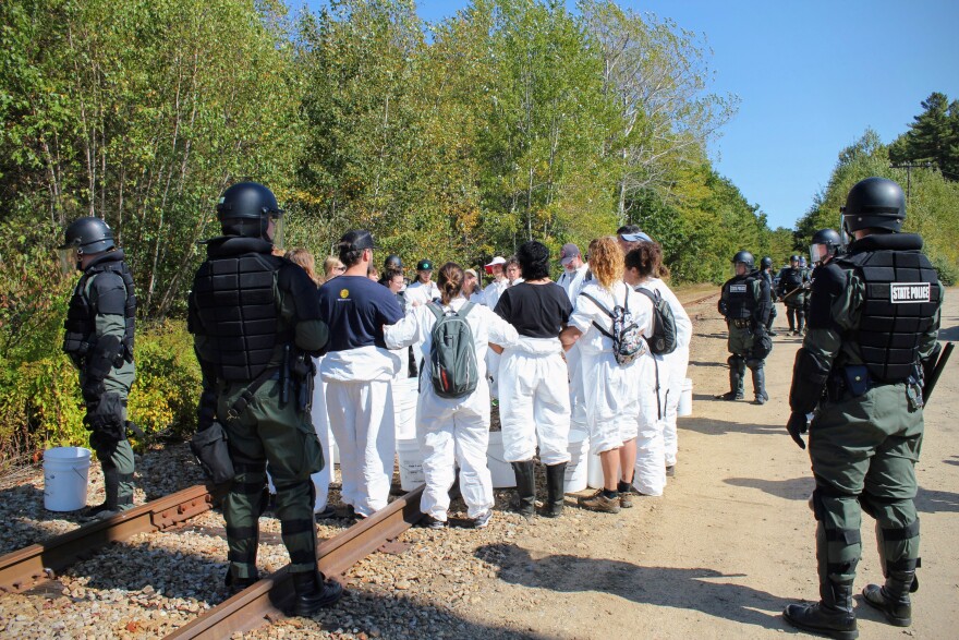 Riot police surround a group of protesters who were later charged with criminally trespassing on private property Merrimack Station.