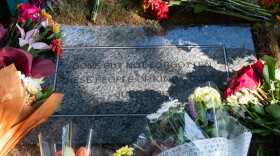 A headstone surrounded by flowers.