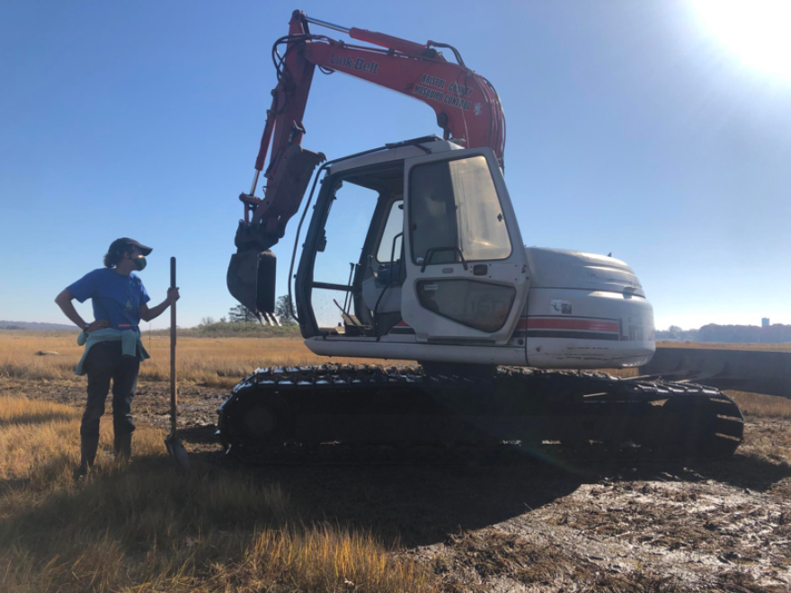 Wenley Ferguson, director of habitat restoration for Save the Bay in Rhode Island, stands by the excavator on the Little Bay salt marsh in Fairhaven.