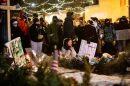 A woman kneels and prays as hundreds gather around a growing memorial site at 26th Street West and Nicollet Avenue, where federal agents shot and killed a 37-year-old Alex Pretti Saturday, Jan. 24, 2026, earlier in the day.