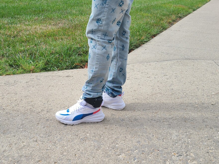jean-clad leg with an ankle monitor