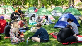 A cluster of tents and demonstrators are seen on the Illinois State University Quad