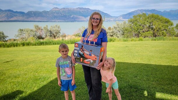 Rebecca Winters and her two kids, Jay and Evie, show off their new life raft with Utah Lake in the background.