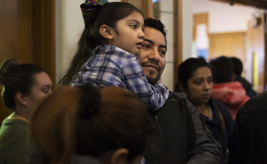 Garcia holds Amanda, 5, as she looks for her sisters after Sunday Mass. Nov. 19, 2017