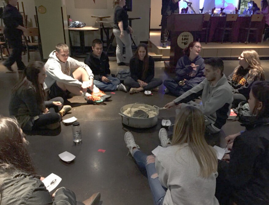 Those tagged as poor during the Hunger Banquet at St. John Fisher College must sit on the floor, and are fed only rice.