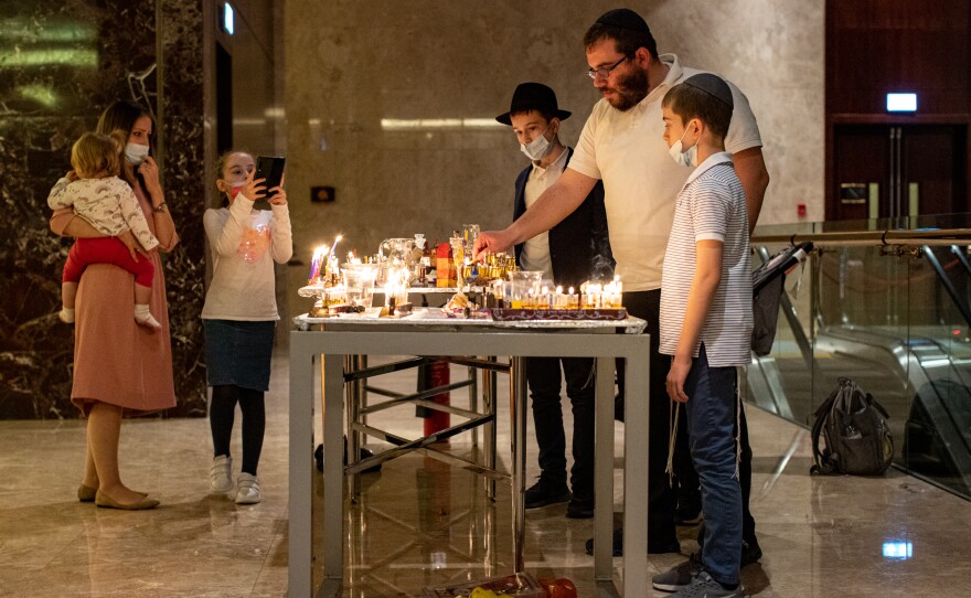 An Israeli family lights menorahs during a Hanukkah celebration at the Conrad Hotel in Dubai on Dec. 16.