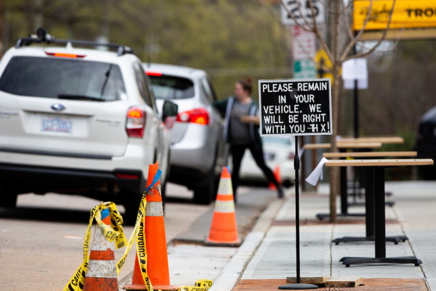 In this March 2020 file photo, customers at Trophy Brewing in Raleigh are directed to remain in their cars to receive service. 