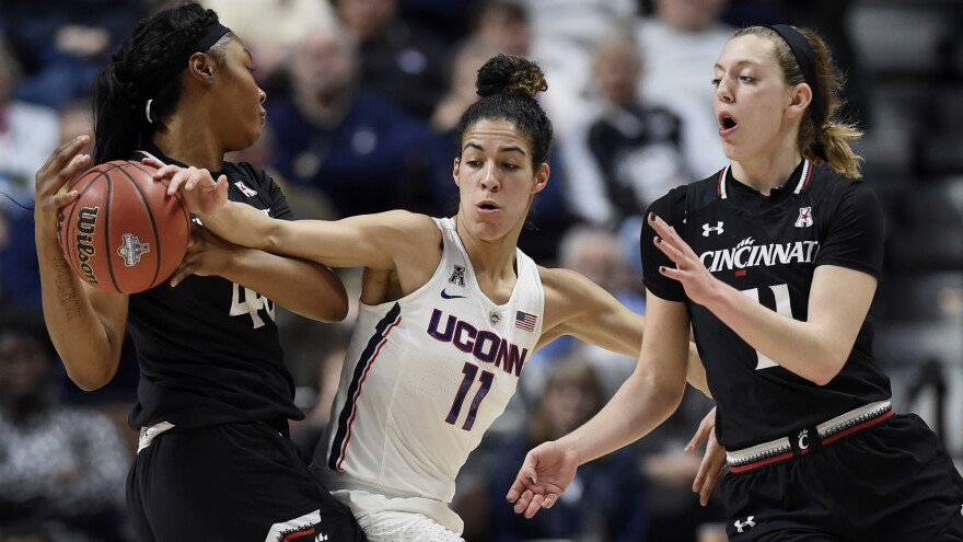At the American Athletic Conference tournament semifinals earlier this month in Uncasville, Conn., Cincinnati's Andeija Puckett, left, looks to pass to Sam Rodgers, right, under pressure from Connecticut's Kia Nurse. Connecticut is the first overall seed in the NCAA women's basketball tournament that begins on Saturday.