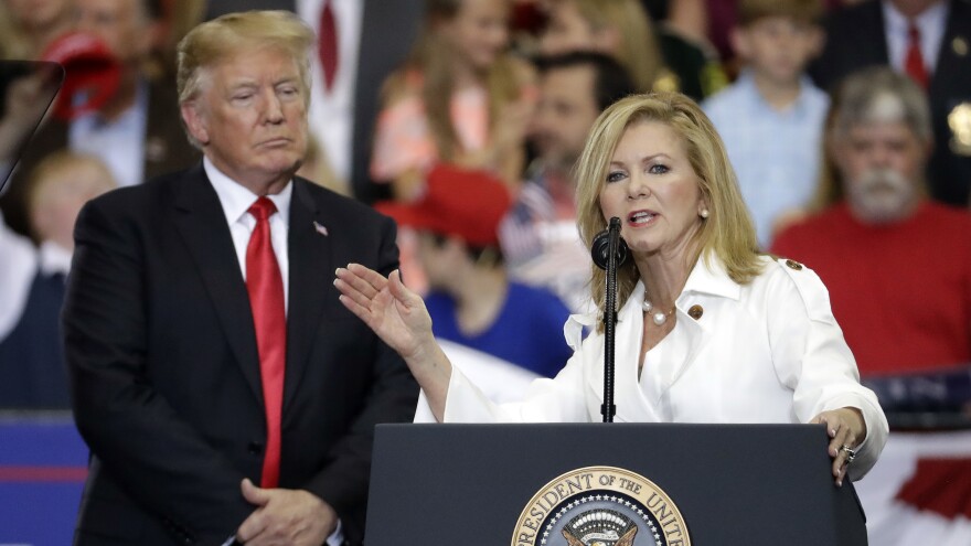 President Donald Trump listening as Rep. Marsha Blackburn, R-Tenn., speaks at a rally in Nashville, Tenn., in May.