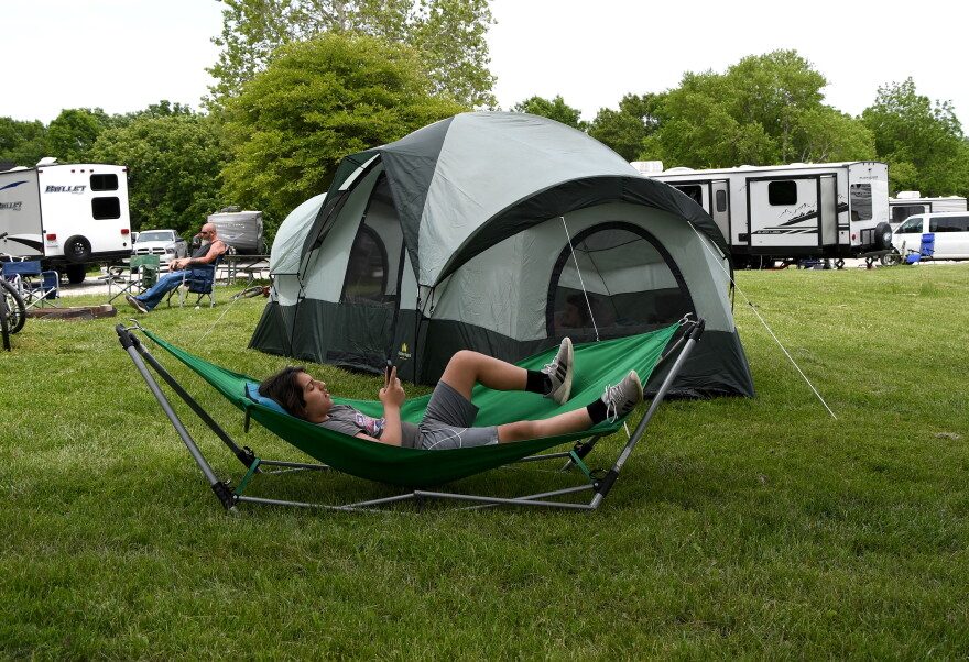A man lying on a cot in the park