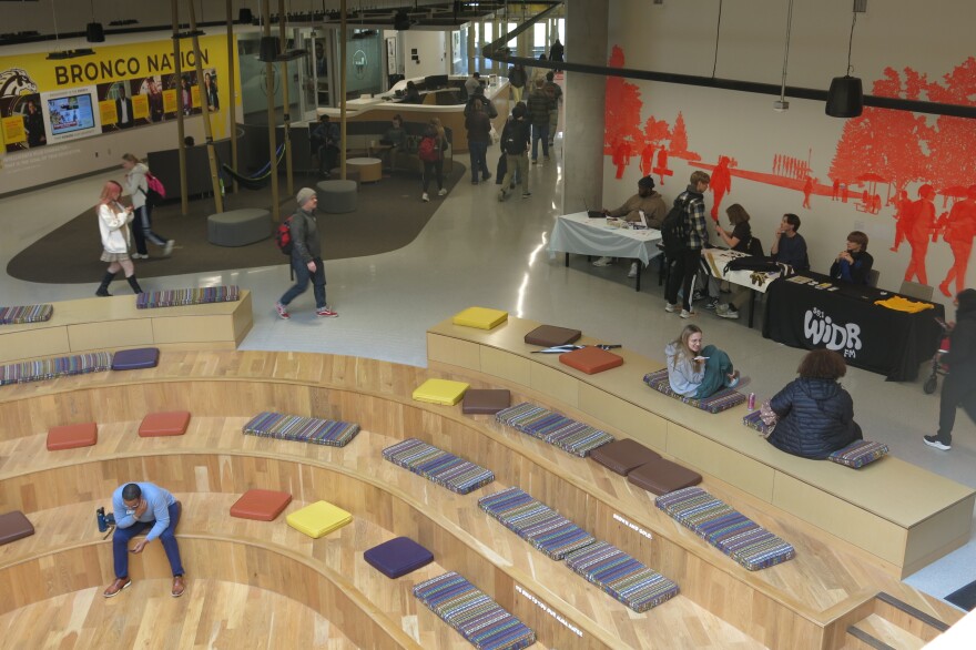 Students gather at tables and steps in Western Michigan University's student center. 