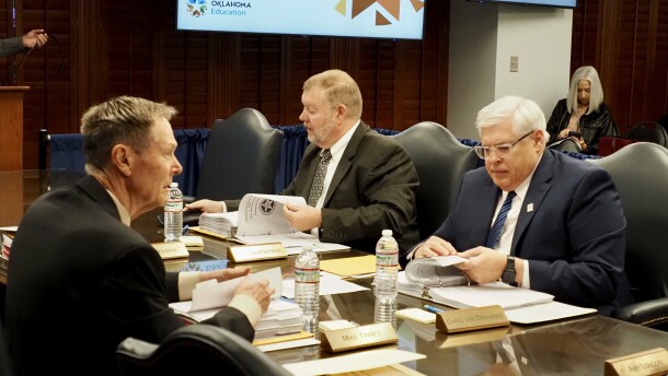 Oklahoma State Board of Education members, from left, Mike Tinney, Ryan Deatherage and Chris Van Denhende review their board packets before a meeting Thursday at the Oklahoma State Department of Education in Oklahoma City.
