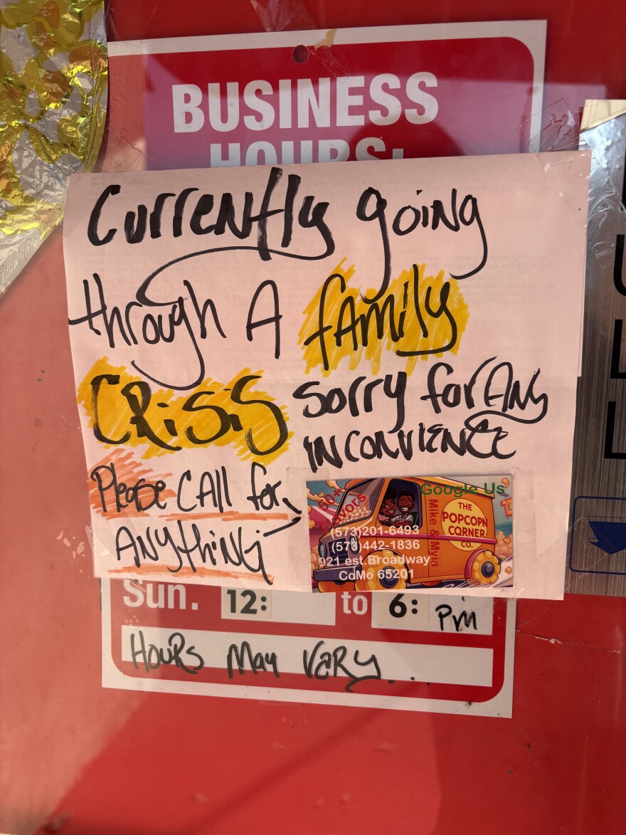 A sign on the door of The Popcorn Corner in downtown Columbia. Written is black marker are the words "Currently going through a family crisis, sorry for any inconvenience." 